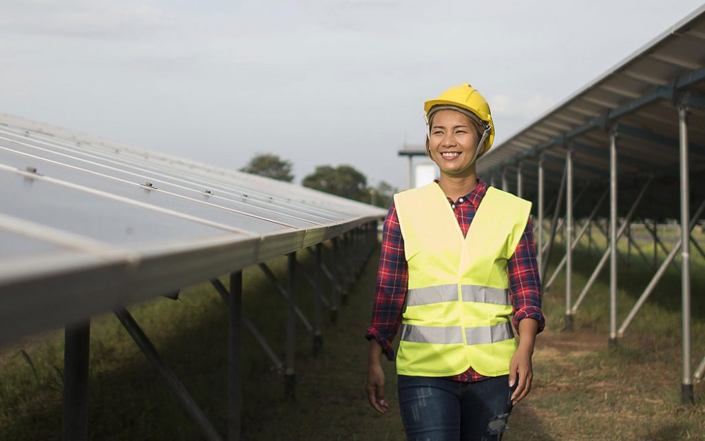 Renewable energy professional walking through solar farm