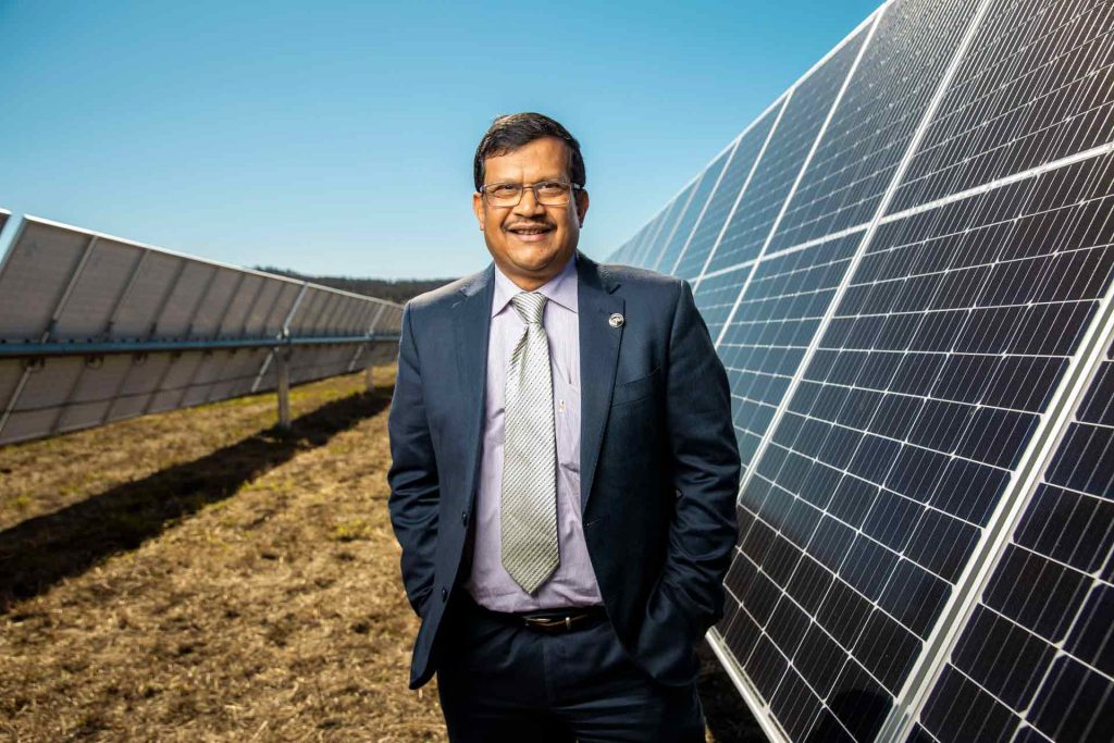 The University of Queensland's Professor Tapan Saha stands in front of a solar array at Warwick solar farm